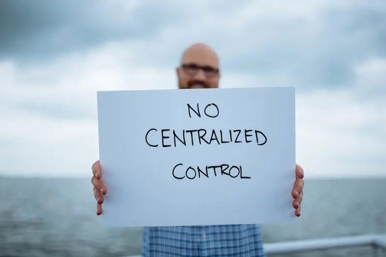 Man holding a sign saying 'no centralised control'